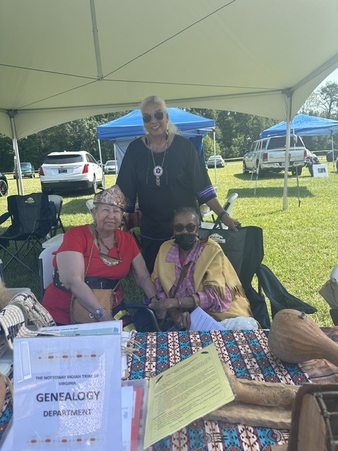Tribal members seated at the genealogy department table under the canopy