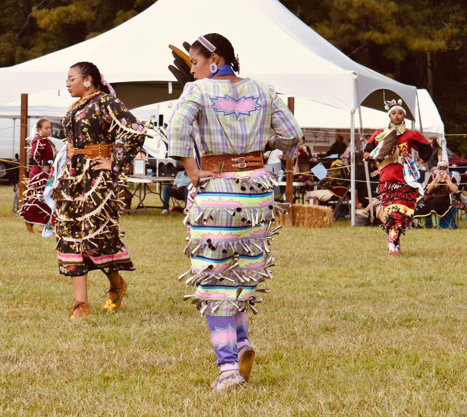 Jingle-dress dancers mid-dance on the field at the powwow