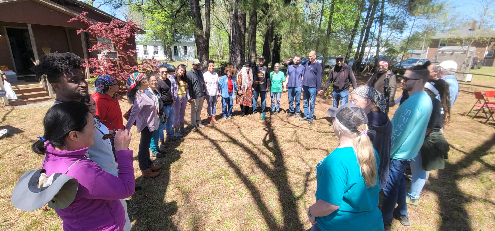 Volunteers standing together in a large circle outdoors