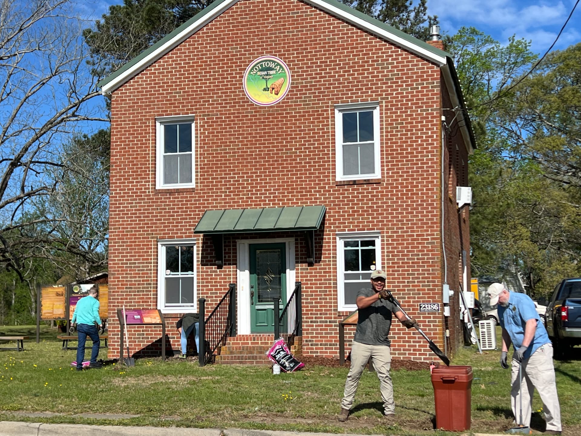 Volunteers caring for the grounds in front of the Nottoway tribal building